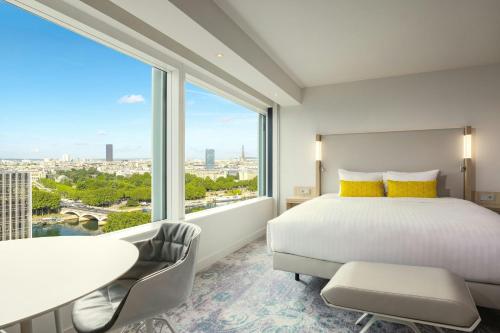 a bedroom with a bed and a desk and a large window at Courtyard by Marriott Paris Gare de Lyon in Paris