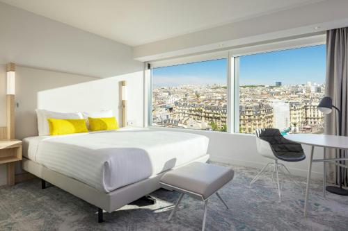 a bedroom with a large bed and a large window at Courtyard by Marriott Paris Gare de Lyon in Paris