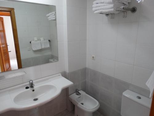 a white bathroom with a sink and a toilet at Apartamentos Beni-Beach in Benidorm