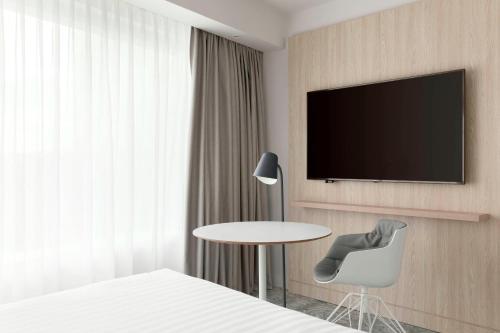 a hotel room with a table and a tv on a wall at Courtyard by Marriott Paris Gare de Lyon in Paris