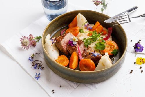 a bowl of food with carrots and meat on a table at Courtyard by Marriott Paris Gare de Lyon in Paris