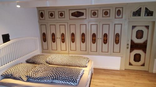 a room with a bed and a cabinet with portraits on it at Hausdeich in Hamburg