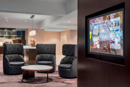 a waiting room with chairs and a flat screen tv at Courtyard By Marriott Jersey City Newport in Jersey City