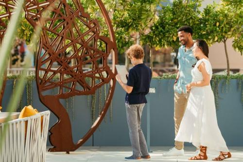 a man and a woman and a boy looking at a sculpture at JW Marriott, Anaheim Resort in Anaheim