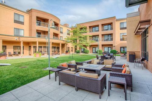 an outdoor patio with tables and chairs in front of a building at Courtyard Fargo Moorhead, MN in Moorhead