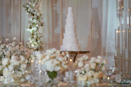 a white wedding cake on a table with flowers at JW Marriott, Anaheim Resort in Anaheim