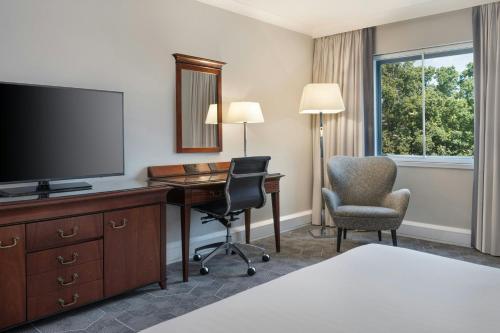 a hotel room with a desk and a television at Delta Hotels by Marriott Newcastle Gateshead in Newcastle upon Tyne