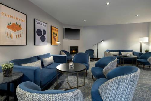 a waiting room with blue couches and tables at Delta Hotels by Marriott Newcastle Gateshead in Newcastle upon Tyne