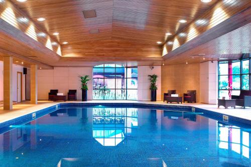 a large swimming pool in a hotel lobby with a large pool at Delta Hotels by Marriott Newcastle Gateshead in Newcastle upon Tyne