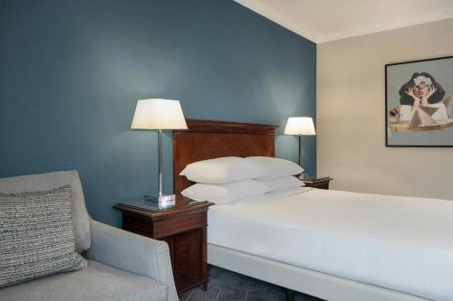 a hotel room with a bed and a chair at Delta Hotels by Marriott Newcastle Gateshead in Newcastle upon Tyne