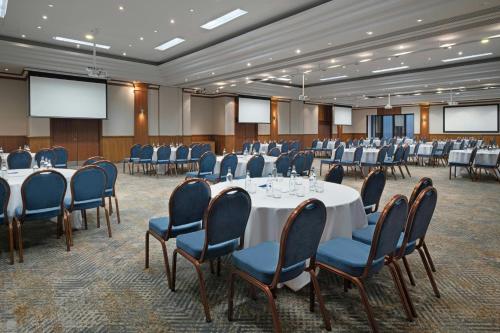a conference room with tables and chairs and screens at Delta Hotels by Marriott Newcastle Gateshead in Newcastle upon Tyne