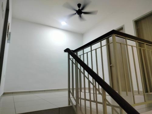 a ceiling fan in a room with a staircase at Naira Homestay in Bedung