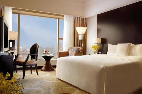 a bedroom with a bed and a desk and a window at Sheraton Ningbo Hotel - Tianyi Square in Ningbo