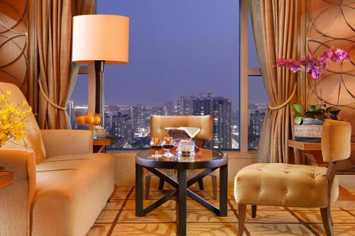 a living room with a table and a large window at Sheraton Ningbo Hotel - Tianyi Square in Ningbo