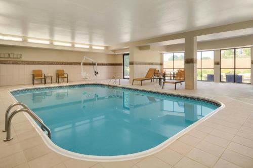 a pool in a hotel with chairs and tables at Courtyard Akron Fairlawn in Montrose