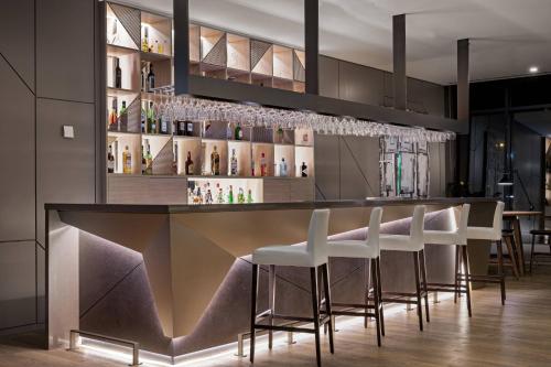 a bar with white stools in a restaurant at AC Hotel Porto by Marriott in Porto