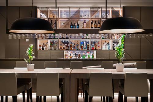 a dining room with a table and chairs and two lights at AC Hotel Porto by Marriott in Porto