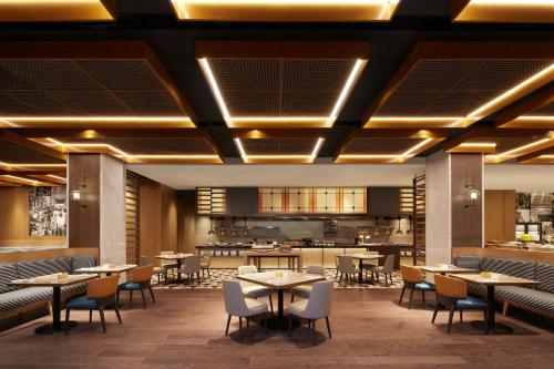 a restaurant with tables and chairs and a bar at Courtyard by Marriott Nanning Wuxiang in Nanning