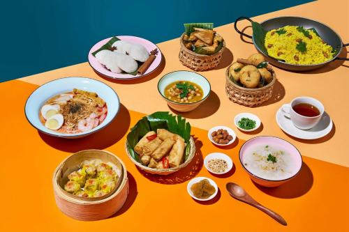 a table with many plates of food on it at Aloft Singapore Novena in Singapore