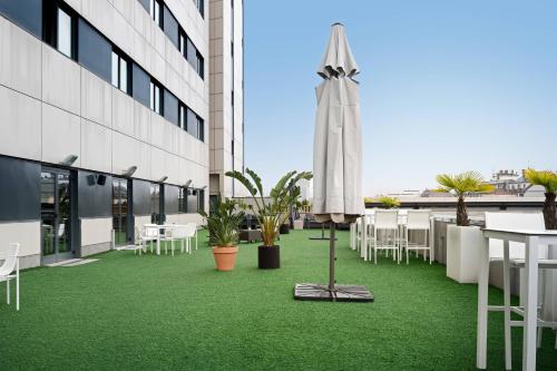 a patio with an umbrella and tables and chairs at AC Hotel Oviedo Fórum by Marriott in Oviedo