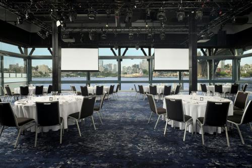 a conference room with tables and chairs with white tablecloths at Pier One Sydney Harbour, Autograph Collection in Sydney