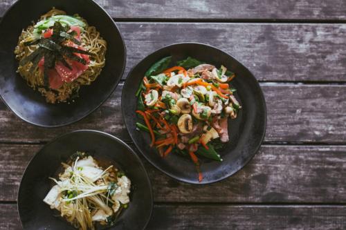 three plates of food on a wooden table at Pier One Sydney Harbour, Autograph Collection in Sydney