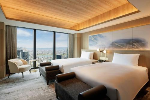 two beds in a hotel room with a view at THE OSAKA STATION HOTEL, Autograph Collection in Osaka