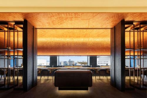 a dining room with a table and chairs and a large window at THE OSAKA STATION HOTEL, Autograph Collection in Osaka