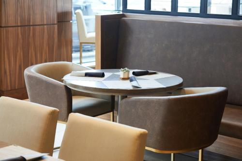 a table and chairs in a restaurant with a table and chairs at AC Hotel Portland Downtown-Waterfront, ME in Portland
