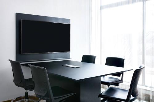 a conference room with a table with chairs and a flat screen tv at AC Hotel Portland Downtown-Waterfront, ME in Portland