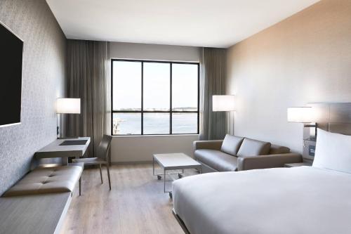 a hotel room with a bed and a couch at AC Hotel Portland Downtown-Waterfront, ME in Portland