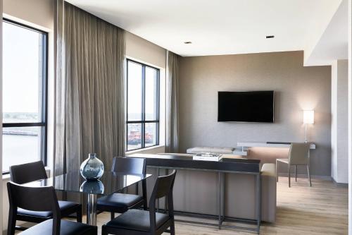 a living room with a table and chairs and a television at AC Hotel Portland Downtown-Waterfront, ME in Portland