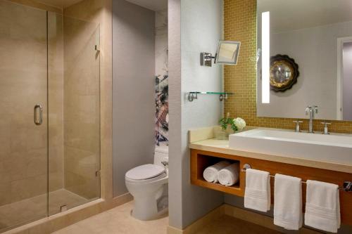 a bathroom with a sink and a toilet and a shower at Renaissance Palm Springs Hotel in Palm Springs