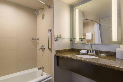 a bathroom with a sink and a tub and a mirror at Renaissance Palm Springs Hotel in Palm Springs
