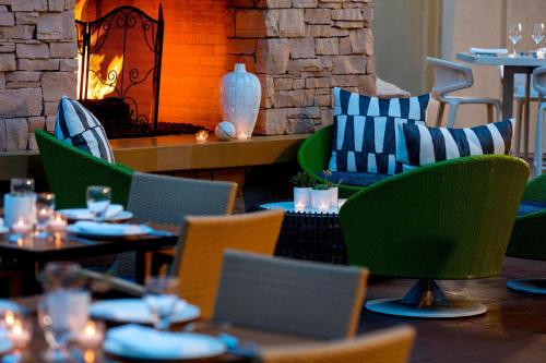 a restaurant with tables and chairs and a fireplace at Renaissance Palm Springs Hotel in Palm Springs