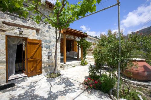 an external view of a stone house with a garden at Blue Cottage in Apsiou