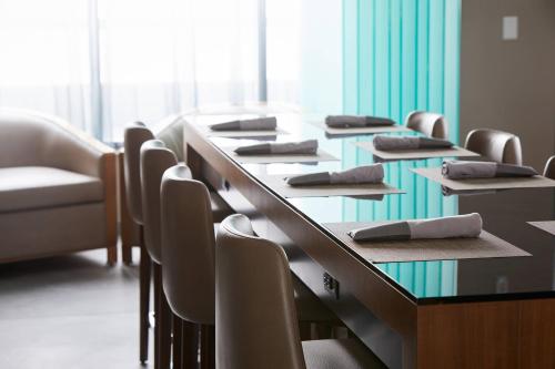 a row of tables and chairs in a room at AC Hotel by Marriott Raleigh North Hills in Raleigh