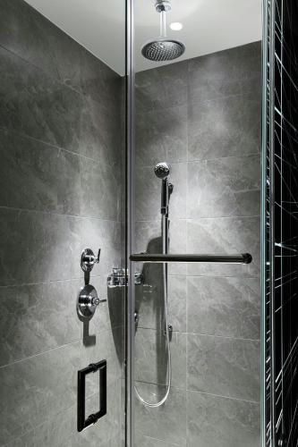 a shower with a glass door in a bathroom at AC Hotel by Marriott Raleigh North Hills in Raleigh