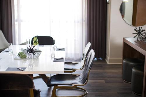 a dining room table with chairs and a mirror at Renaissance Raleigh North Hills Hotel in Raleigh