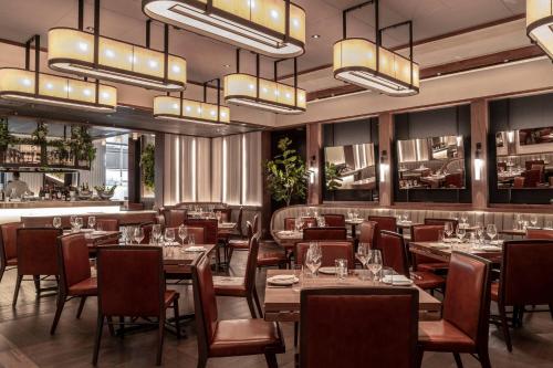 a restaurant with tables and chairs and chandeliers at Bvlgari Hotel London in London