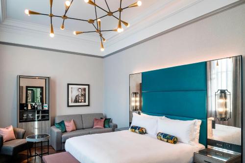a bedroom with a large bed and a couch at The Dixon, Tower Bridge, Autograph Collection in London