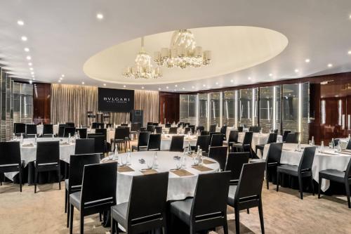 a conference room with tables and chairs and a chandelier at Bvlgari Hotel London in London