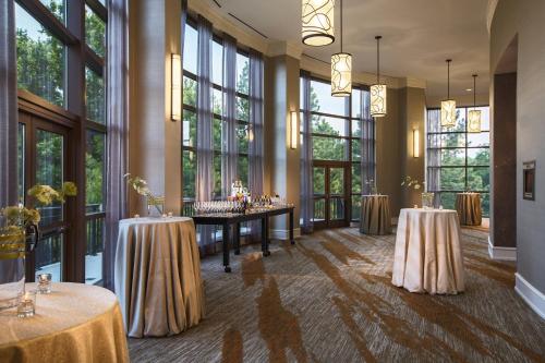 a banquet hall with two tables and large windows at Renaissance Raleigh North Hills Hotel in Raleigh
