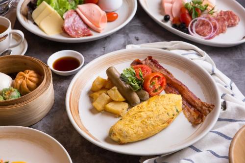 een tafel met borden met ontbijtproducten bij Renaissance Pattaya Resort & Spa in Na Jomtien