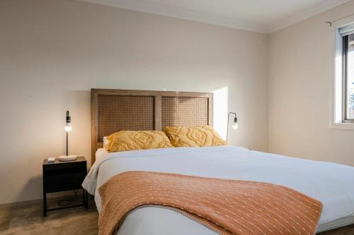 a bedroom with a large white bed and a window at Central Modern Spacous Townhouse 290B in Temora