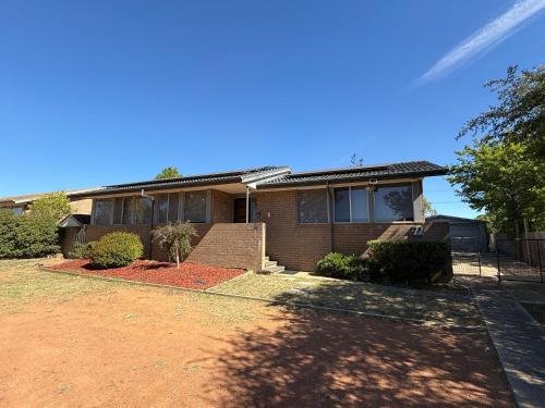 a brick house with a tree in front of it at Page 3BR House in Canberra