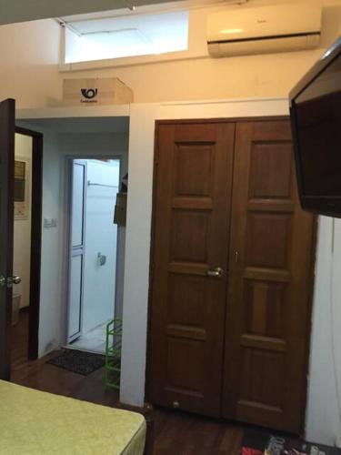 a room with wooden cabinets and a television and a door at Master Room at Orchard Road in Singapore
