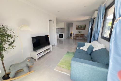a living room with a blue couch and a tv at A2-Family friendly 2B1BHouse nr airport backyard&carparking in Perth