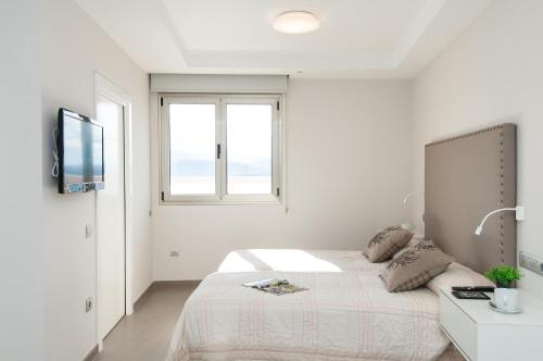 Habitación blanca con cama y ventana en Apartment Las Canteras Nautilus 8D, en Las Palmas de Gran Canaria