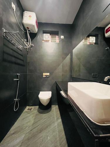 a bathroom with a white sink and a toilet at The Forest Grove by Living Circle in Yelagiri